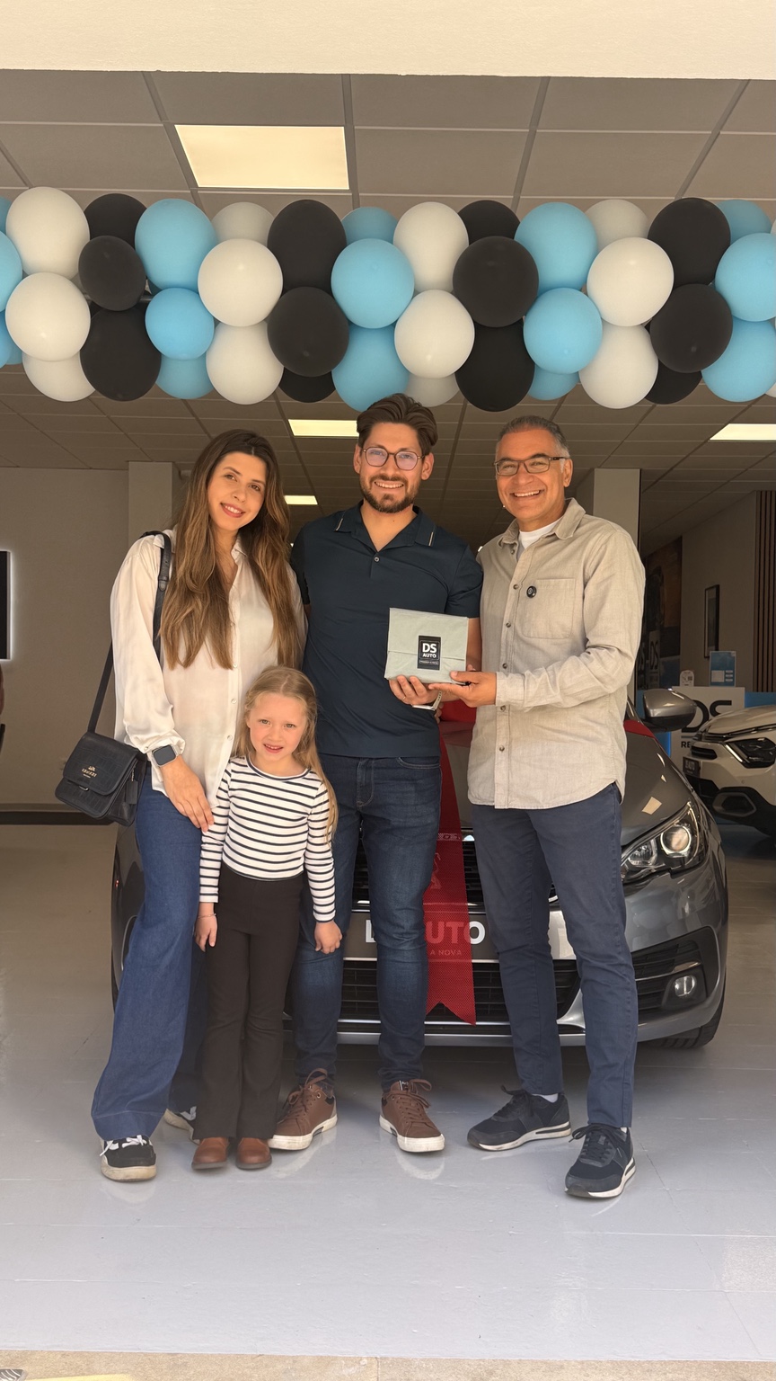 Sérgio Costa with a family during a vehicle delivery at SG Motors
